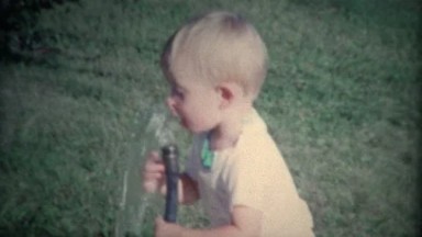 (8mm Vintage) Little Boy Drinking From Outdoor Garden Hose