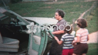 (8mm Vintage) 1954 Family Inspecting Wrecked Car In Yard, Iowa, USA.