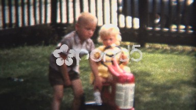 (8mm Vintage) 1954 Brother Pushing Sister Toy Tractor. Iowa, USA.