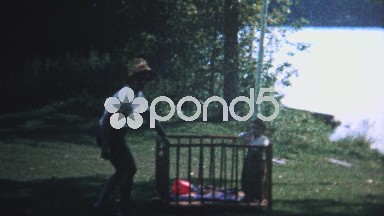(8mm Vintage) 1966 Mom Pulling Child Across Lawn While Caged