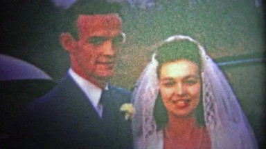 1954: Recently married couple walks into their new home, man smokes pipe.