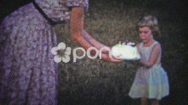Tennessee, USA (1954): Woman handing child large birthday cake to pose with.