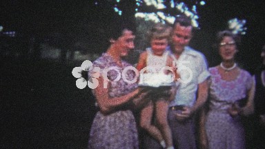 Tennessee, USA (1954): Child grabbing at birthday cake while being held.