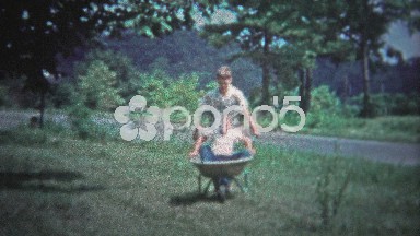 Tennessee, USA - 1953: Older Brother Pushing Sibling in Wheelbarrow for Play