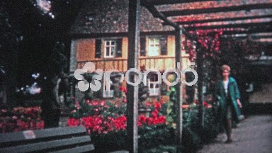 Hamburg, Germany (1966): Women walking through red flower conservatory garden