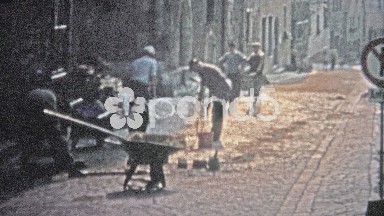 Hamburg, Germany (1966): Man repairing cobblestone road with old country