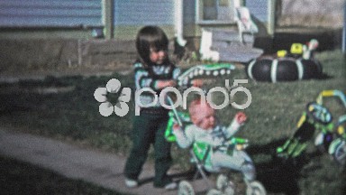 Boulder, CO. USA - 1974: Little Girl Pushing Baby Brother in a Stroller