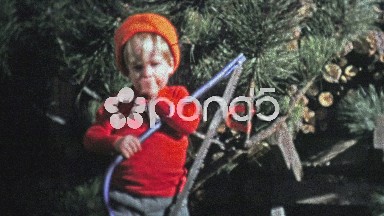 1973: Baby holding a Christmas tree saw to mimic Dad.