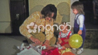 1973: Mom opens up the boy's racecar Christmas gift.