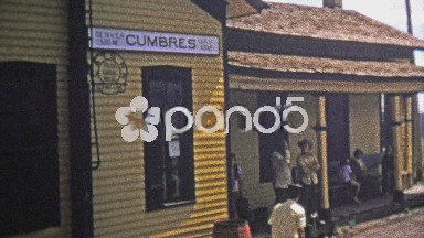 1973: High elevation train station conductor takes tickets and steam locomotive