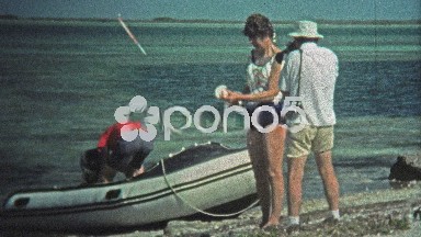 1973: Women fishing shark from the depths of the ocean bay.