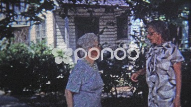 1971: Old women childhood friends sharing embrace and laughter.