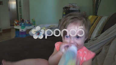 Baby smirking while holding it's bottle.
