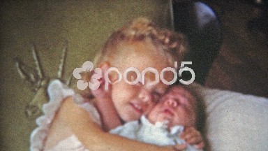 Boulder, Colorado (1951): Big sister holding baby brother kisses him on the head.