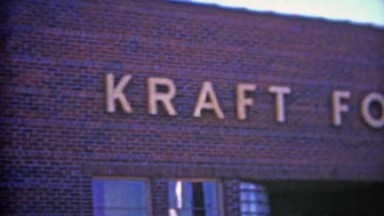 1953: Kraft foods company enterance where two workers emerge.