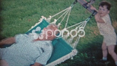 1966: Son Rocking Sleepy Dad in Outdoor Summer Hammock