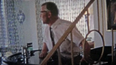 1967: Retro barman mixing drinks private beaded curtain rooms.
