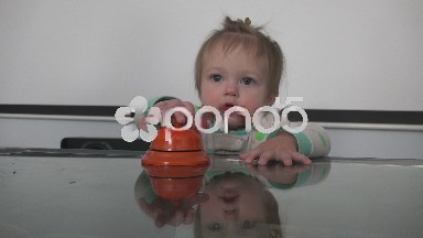 Baby ringing toy bell then eating it.