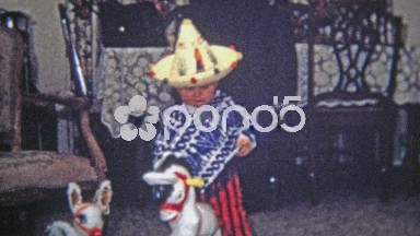 1968: Kid dressed as mexican bandit riding play horse, smoking cigar.