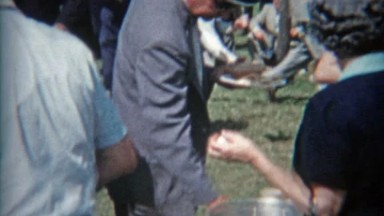 1957: Family reunion gathering people milling about in old time fashion.