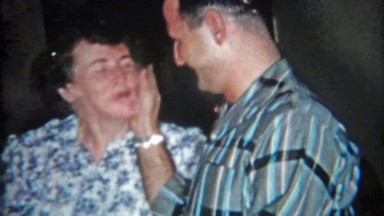 1957: Family laughing having fun around the kitchen table.