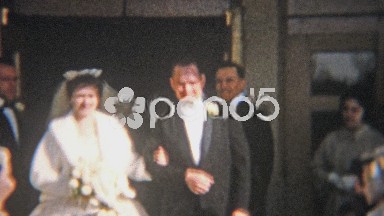 1964: Just married rice thrown at couples head as they escape.