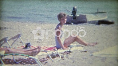 1961: Family relaxing at the beach on a hot sunny day.