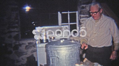 1965: Man Opening Steaming Hot Pot of Food