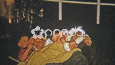 1954: Sons cuddling on couch with father.