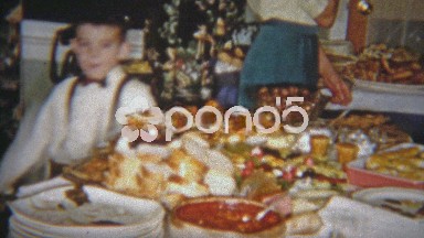 1954: People ceremoniously walking around a table of food.