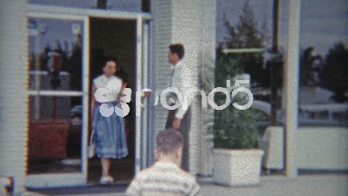 1959: Car saleman opening door for lady and child.