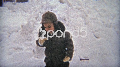 1954: Boy plays in 1st winter storm eating snow being cute.