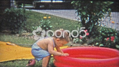 1954: Kiddie pool water too cold for child, bucket refills with warm water.