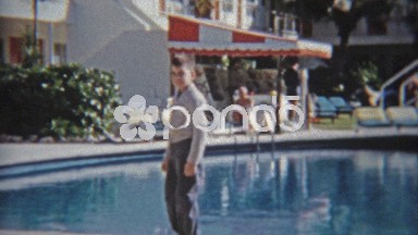 1959: Walking past fancy pool at retro beach hotel style architecture.