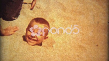 1961: Cute boy buried neck high in beach sand gets out.
