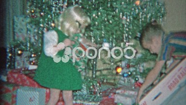 1963: Kid unwrapping road rage electric slot car racer toy for Christmas gift.