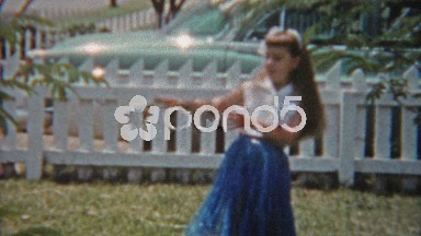 1957: Girl Practicing Hawaiian Style Dance in Backyard Next to Parked Car.