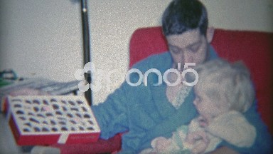 1964: Dad Showing Child Box of Chocolates in Morning Robe