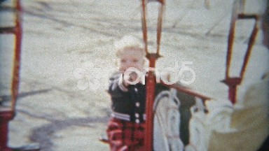 1964: Boy and dad swinging on playground toys and smiling hard.