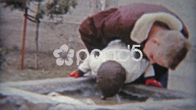 1964: Dad lifting up cute boy child up to water drinking fountain in public