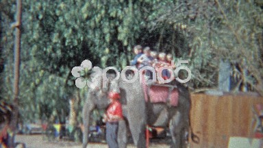 1963: Kids riding on Asian elephant at amusement park ride for privileged
