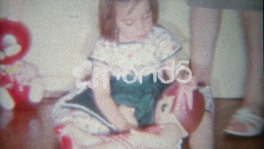 1963: Creepy blow up doll toy for little girl playing indoors at home.