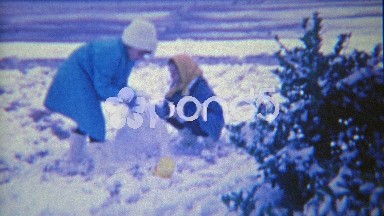 1963: Kids building snowman in front yard of house.