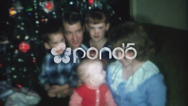 1966: Cute family posing near Christmas tree with 3 children and 2 adults.