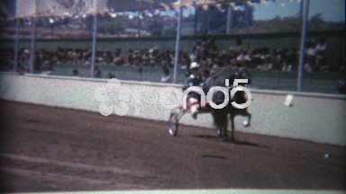 1969: Horse harness racing drivers going around the race track.