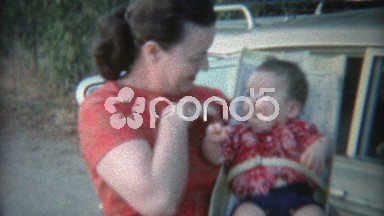 1969: Baby in early style car seat strapped tight.