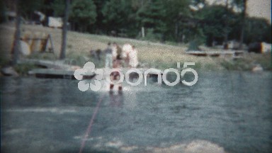 1960: Boy waterskis behind boat showing off his latest tricks.