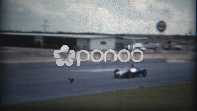 1960: Small car racing on test track with real vintage racecar.