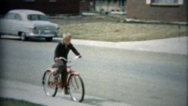 1957: Boy riding bike to meetup with family and boyhood pals.