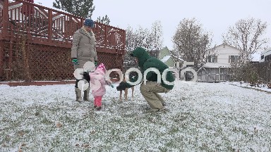 Family play in snowy winter backyard baby figuring out snow.